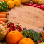Vibrant variety of fresh fruits and vegetables on a wooden table for healthy eating.